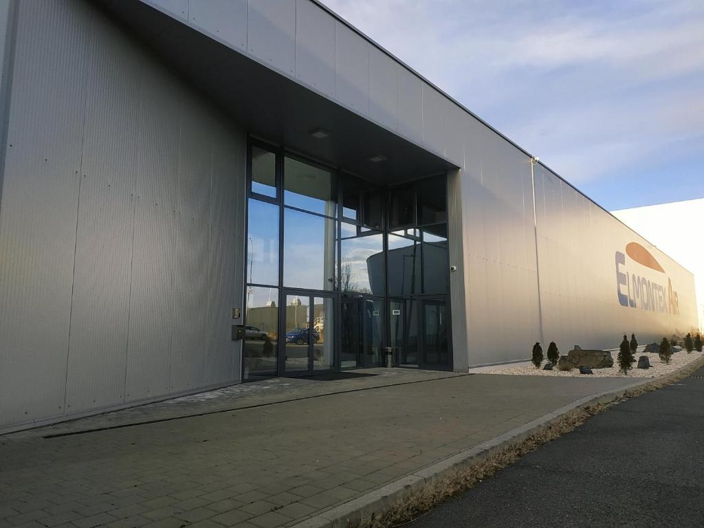 a large building with glass doors on the side of it at Elmontex Air in Mošnov
