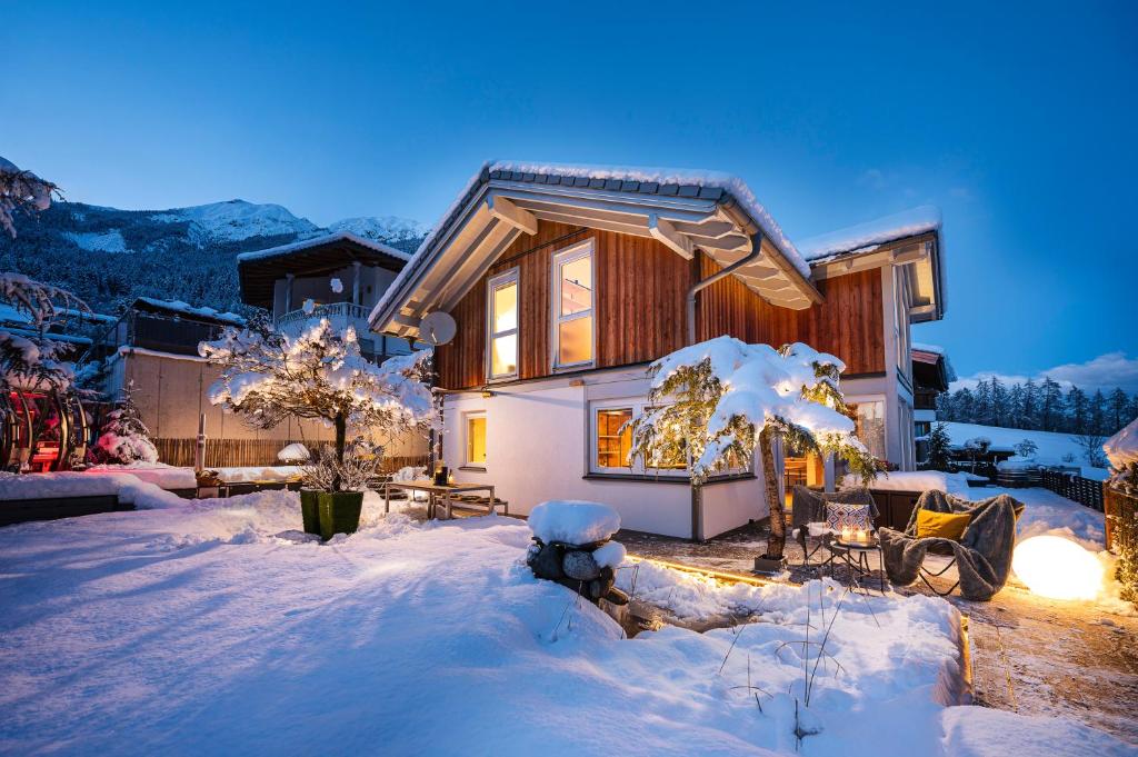 une maison recouverte de neige dans la neige dans l'établissement Ferienhaus zum Stubaier Gletscher - Wiesen, à Telfes im Stubai