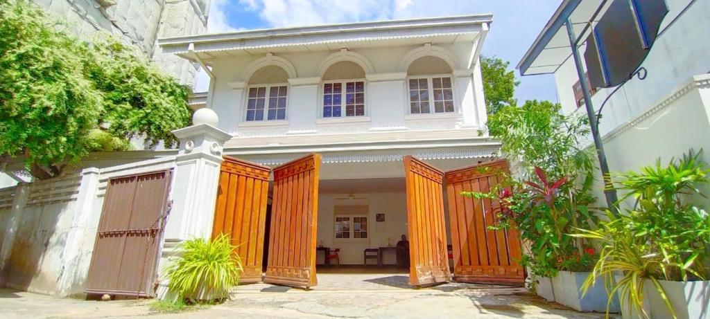 a white house with orange gates in front of it at Tarshish Villa - Colombo in Colombo