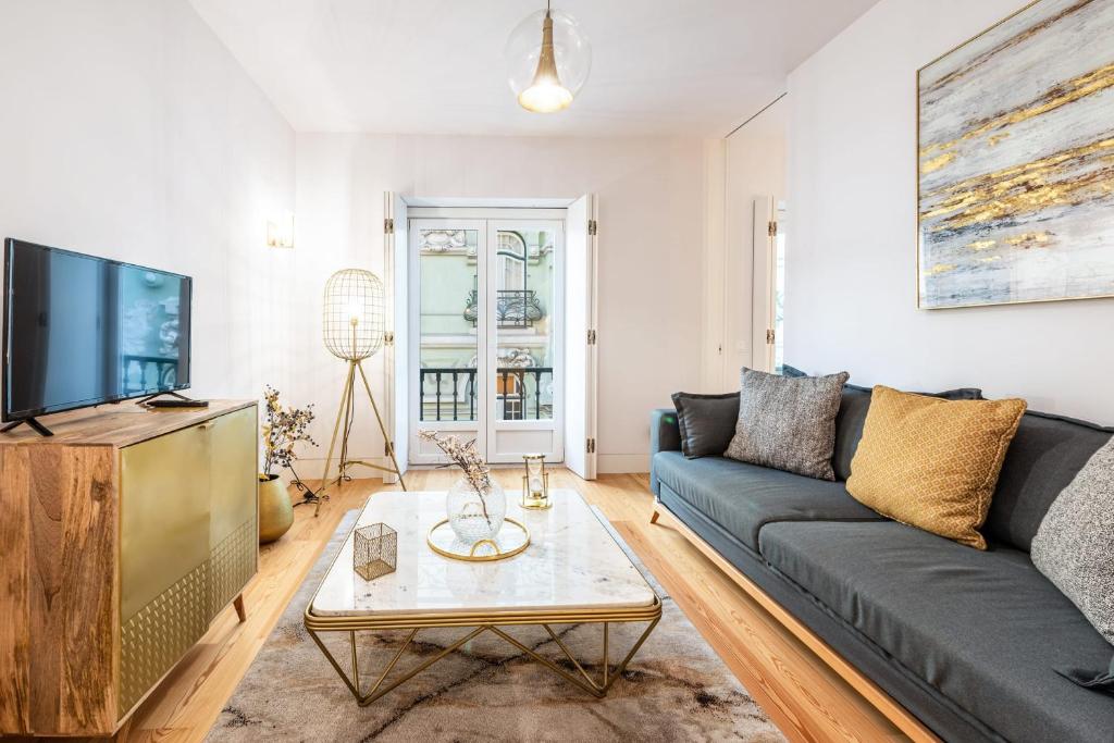 un soggiorno con divano e TV di GuestReady - Baixa Collection Apartment I a Lisbona