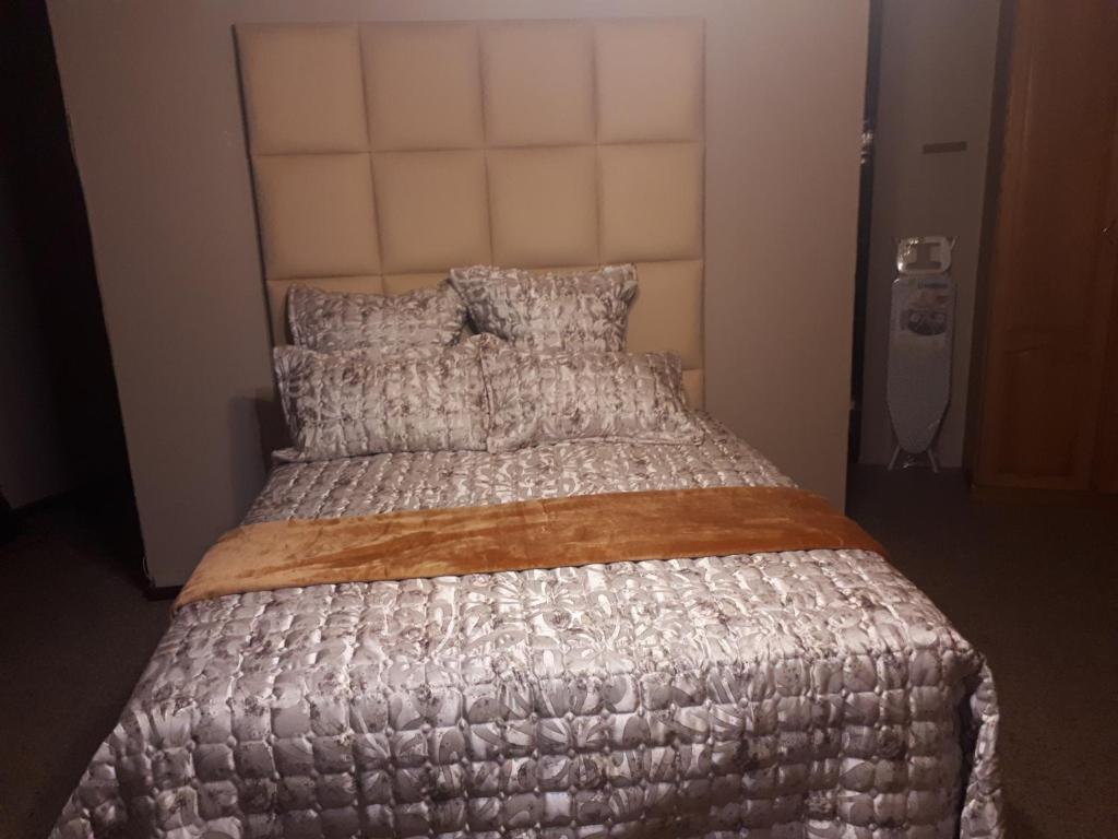 a bedroom with a bed with a silver bedspread at C - Land guest house Meyerton in Meyerton