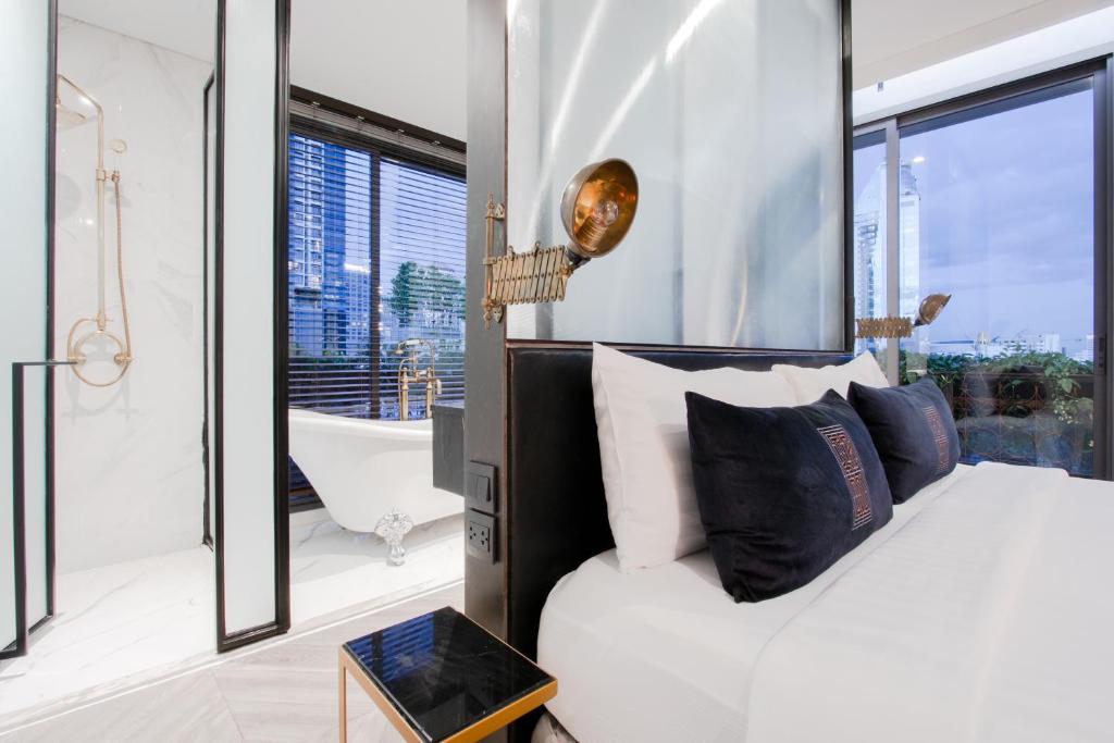 a bedroom with a white bed and a bath tub and a bath tub at IR-ON Hotel in Bangkok