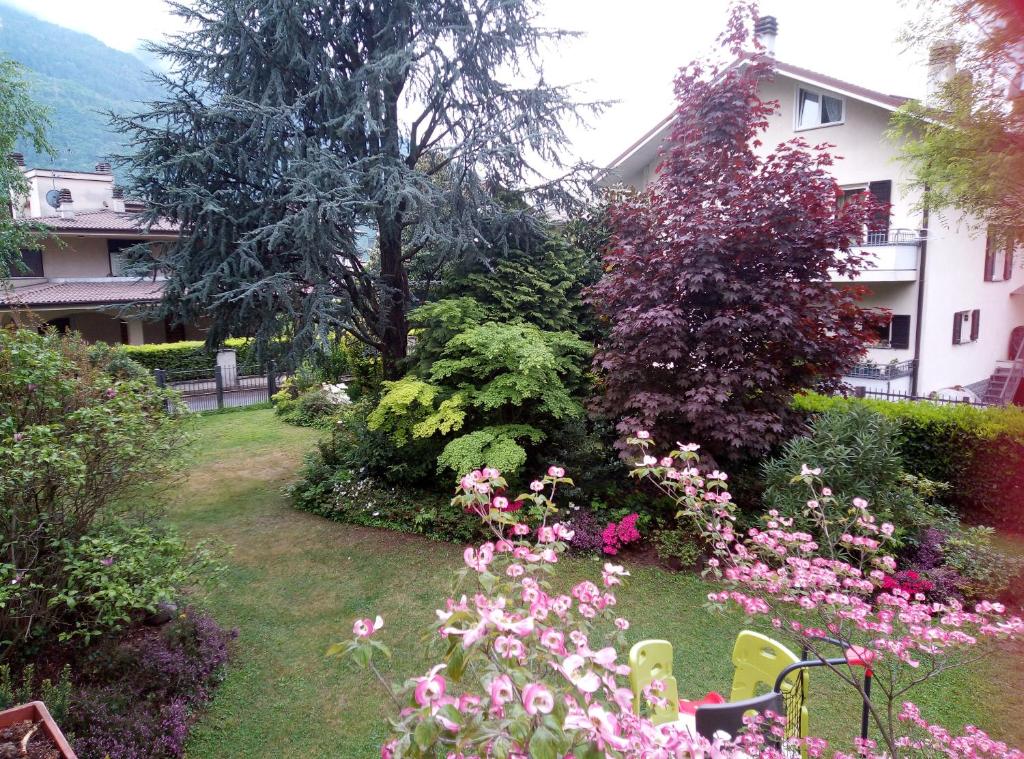 un giardino con fiori rosa e un edificio di B&B da Lori a Tirano