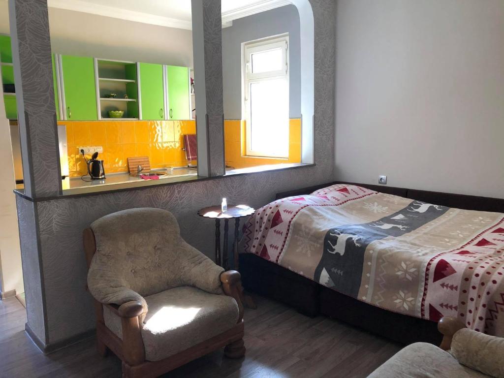 een slaapkamer met een bed, een stoel en een spiegel bij Our house in Borjomi