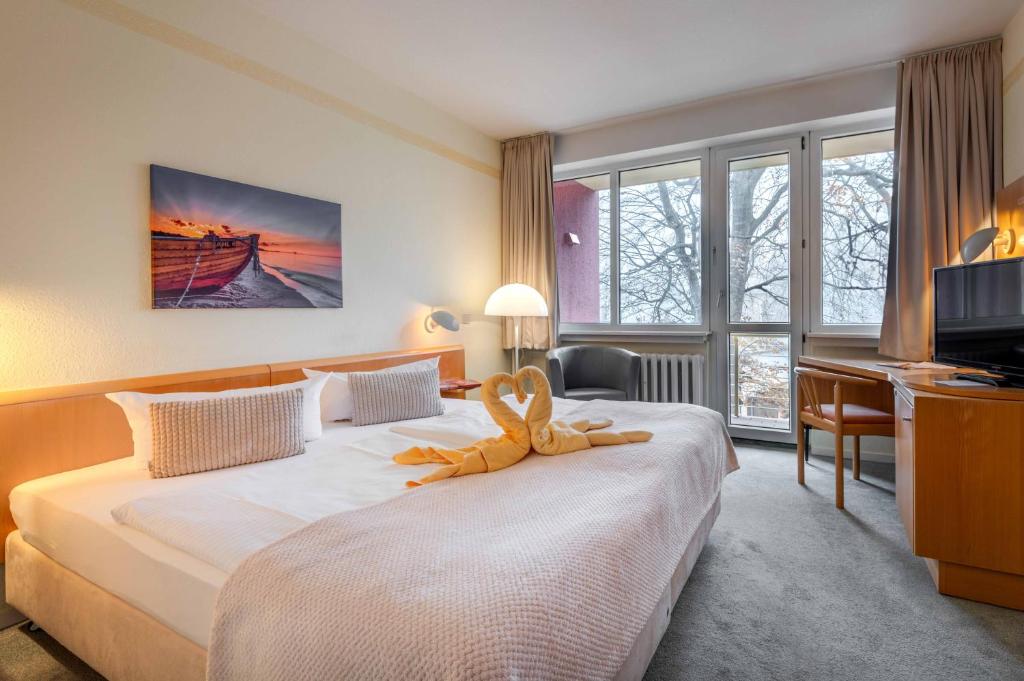 ein Hotelzimmer mit einem Bett mit einem Handtuch darauf in der Unterkunft Hotel Wald und See in Heringsdorf