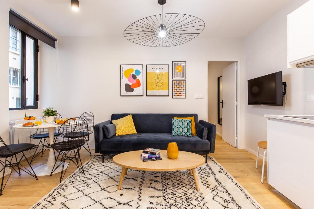 un salon avec un canapé et une table dans l'établissement Charming apartment - 2BR-6P - Grands Boulevards, à Paris