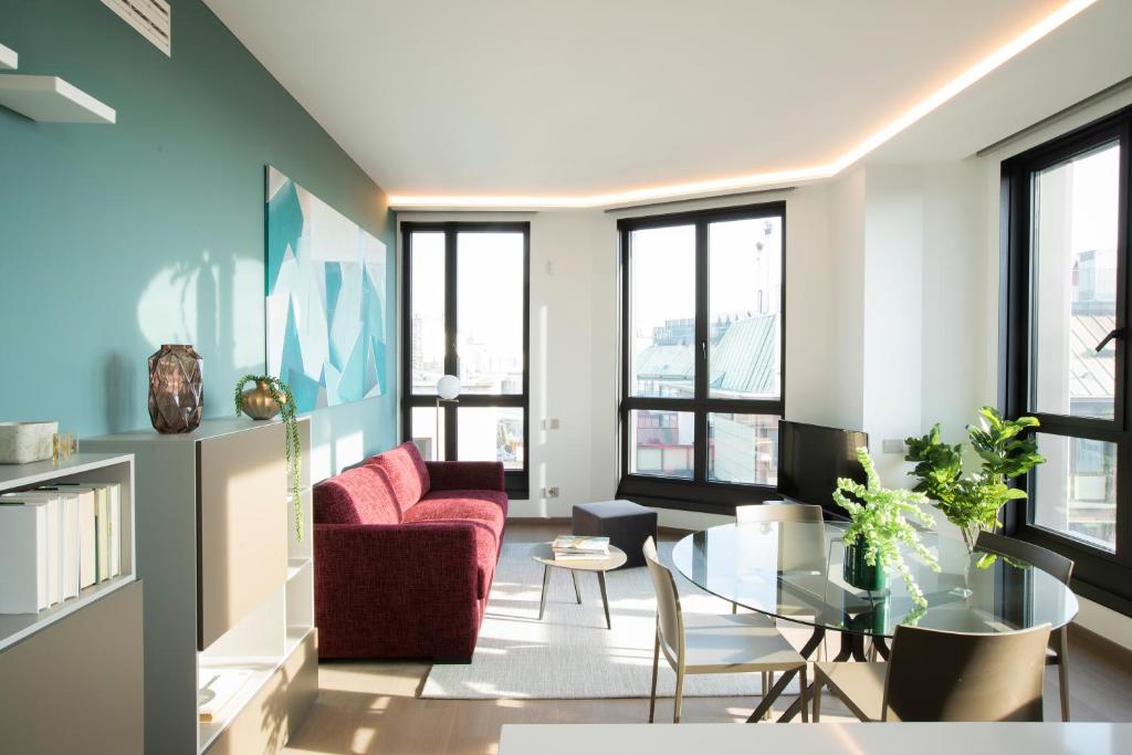 uma sala de estar com um sofá vermelho e uma mesa em Milan Eleven by Brera Apartments em Milão