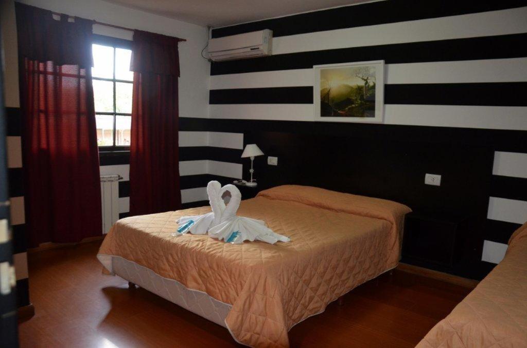 Un dormitorio con una cama con un conejito. en Hotel Valle Del Sol en Merlo