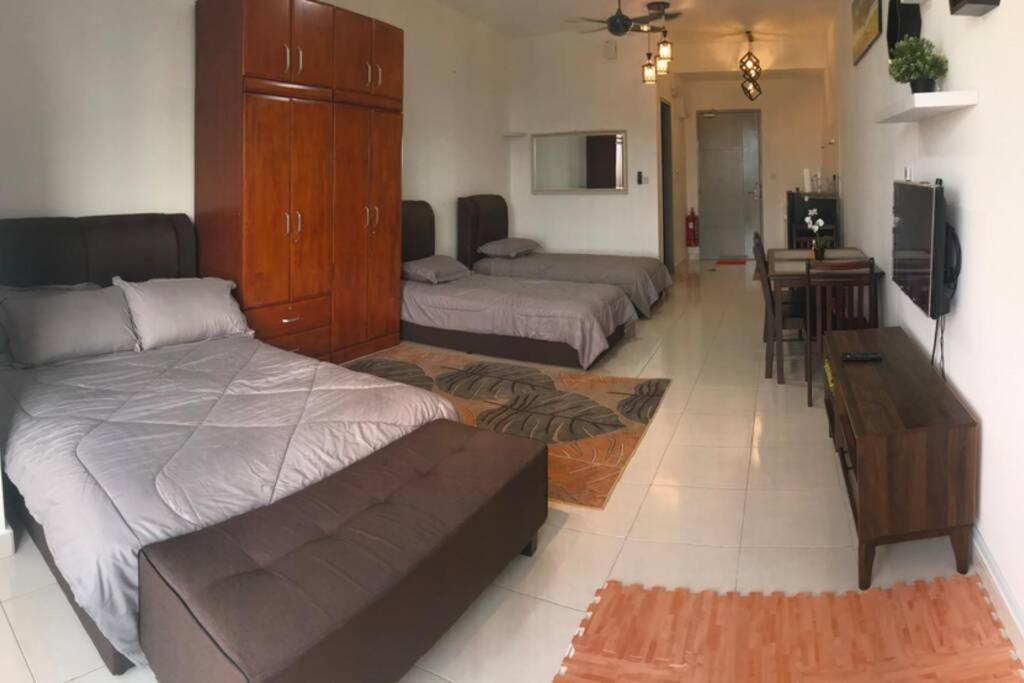 a living room with two beds and a table at HomestayBABA close to UKM, GMI, & more ! in Kajang