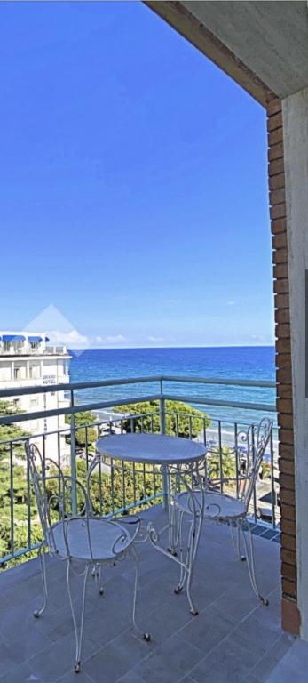 a table and chairs on a balcony overlooking the ocean at residence cristallo in Alassio