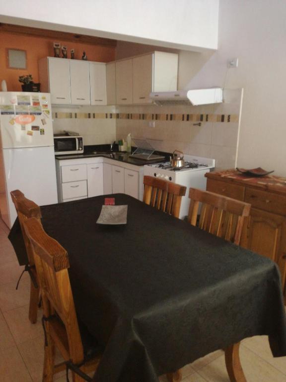 uma cozinha com uma mesa com cadeiras e um frigorífico em Tini em Neuquén