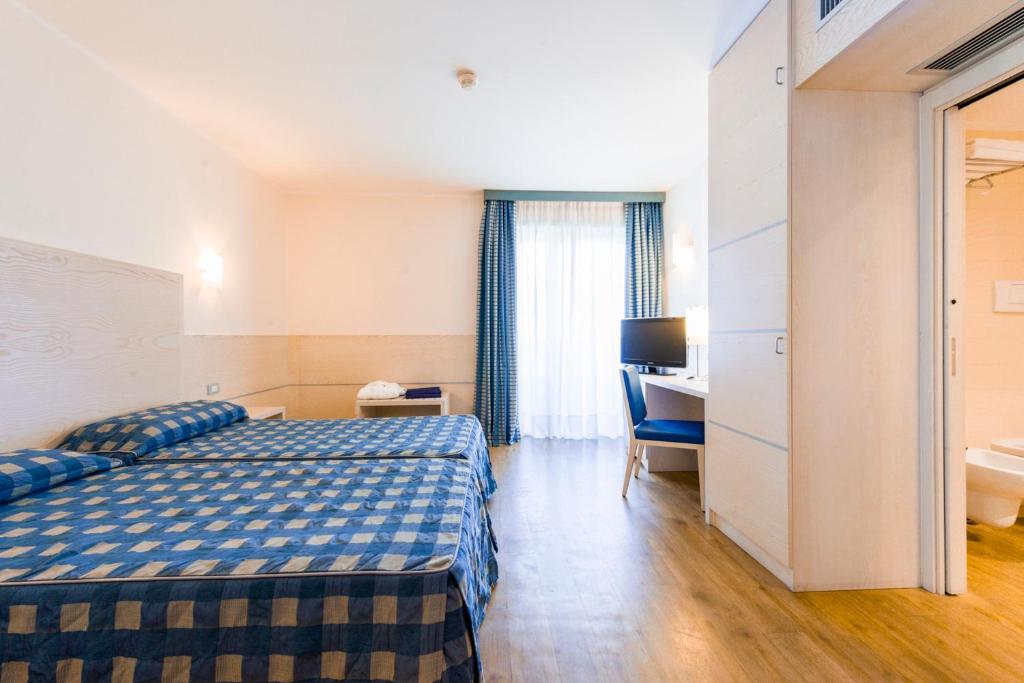 A bed or beds in a room at Caravel Bike Hotel