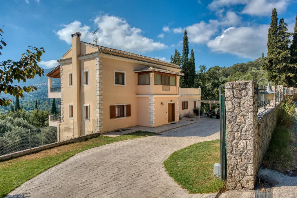 una casa con un muro di pietra e un vialetto di Mansion on the Hill by CorfuEscapes a Virós