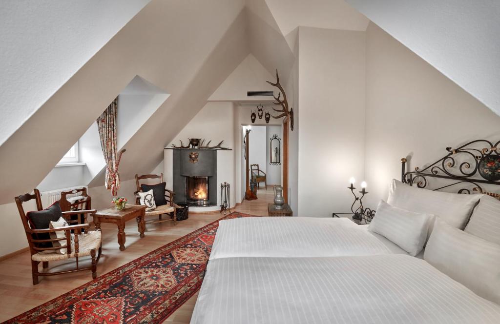 
a living room with a fireplace and a bed at Hotel Schwarzer Adler Innsbruck in Innsbruck
