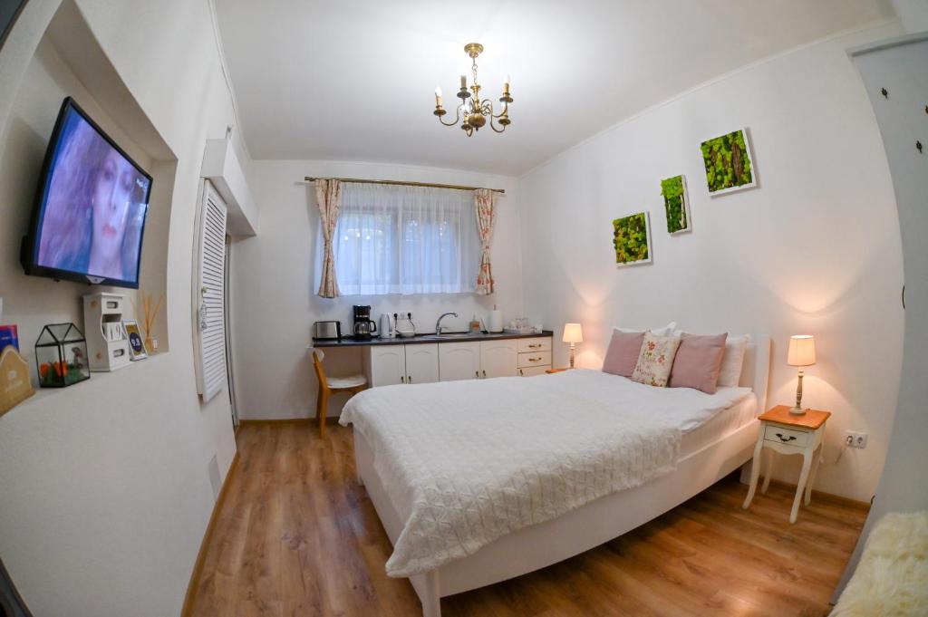 a bedroom with a white bed and a television at Transilvania Apartment in Sibiu