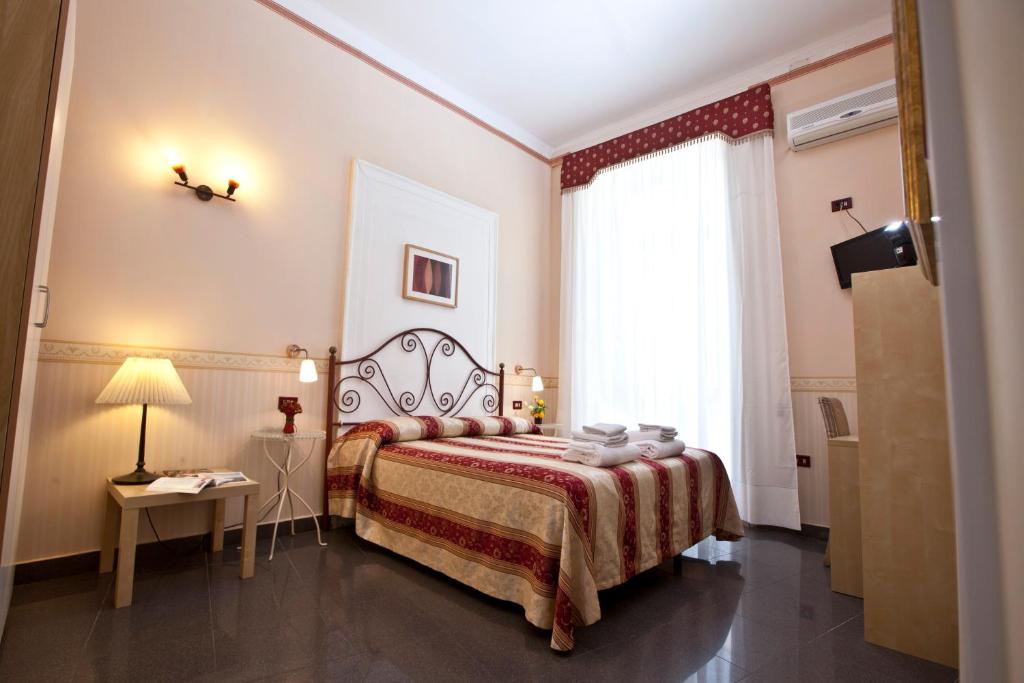 ein Hotelzimmer mit einem Bett und einem Fenster in der Unterkunft B&B MediNaples in Neapel