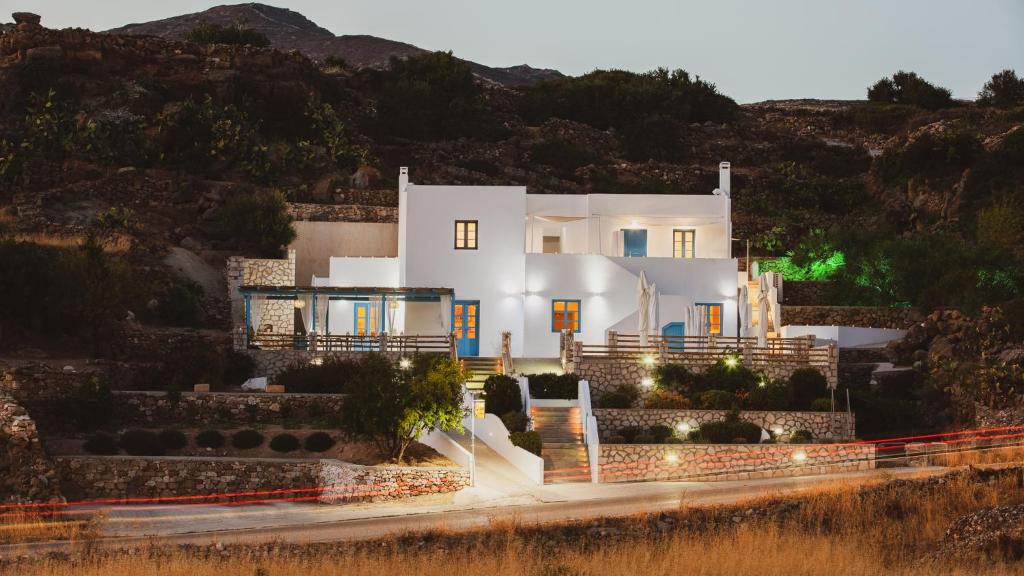 a white house on a hill at night at To Rantevou tis Alykis Rooms & Apartments in Kimolos