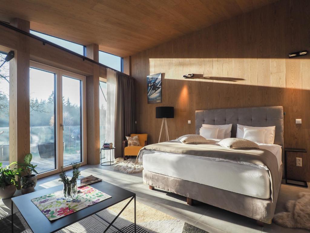 a bedroom with a large bed and a table at CHALEYOTT Mountain Apartments in Harrachov
