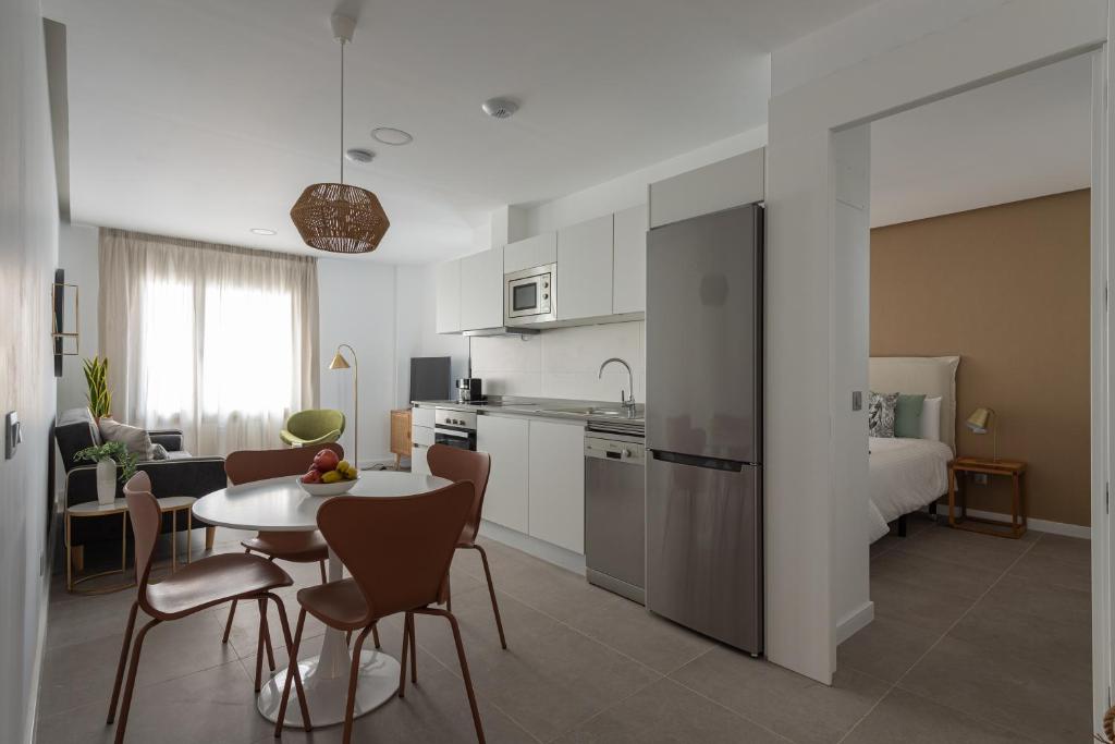 a kitchen and living room with a table and chairs at Royal Flats in Las Palmas de Gran Canaria