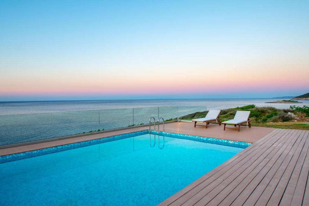 a swimming pool with a view of the ocean at Villa Vrahos - Deja Vu Villas in Agios Nikolaos