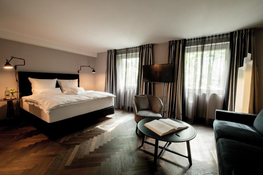 a bedroom with a bed and a chair and a table at Prevôt Restaurant & Hotel in Cologne