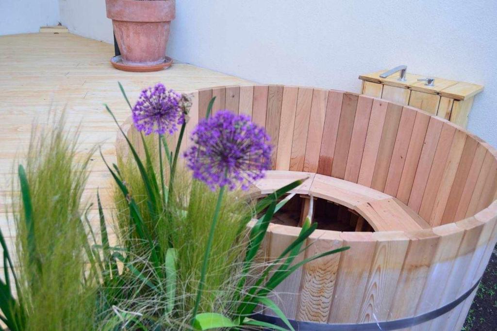 un barril de madera con flores púrpuras en un jardín en Casa Rural Bigotes, en Arlanzón