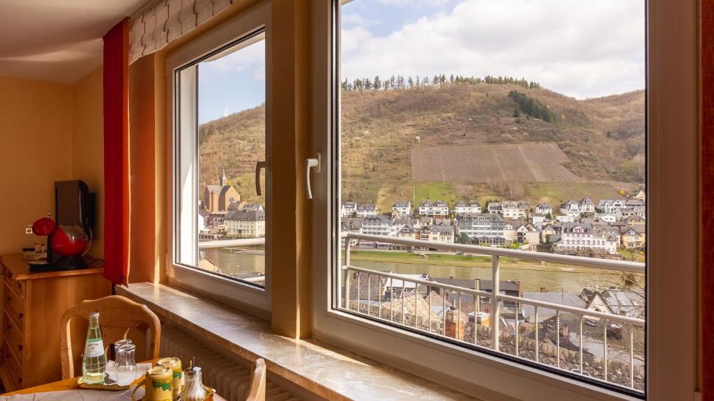 a room with a window with a view of a city at Hotel Villa Tummelchen in Cochem