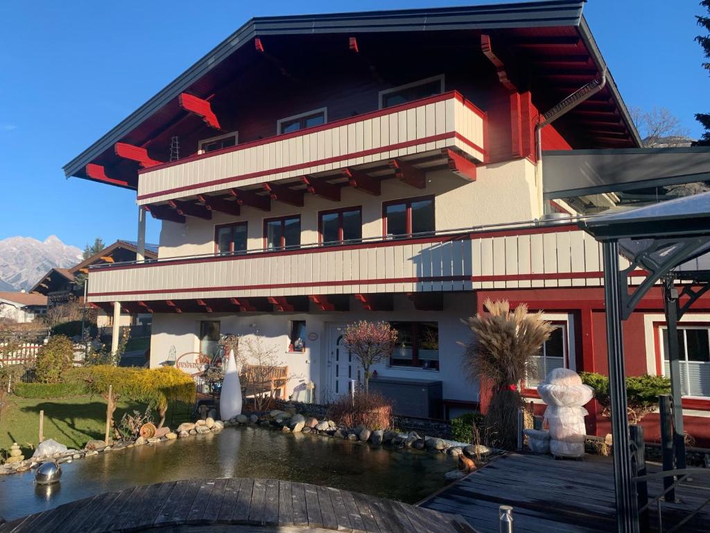 a building with a pond in front of it at Appartement Holiday in Maishofen