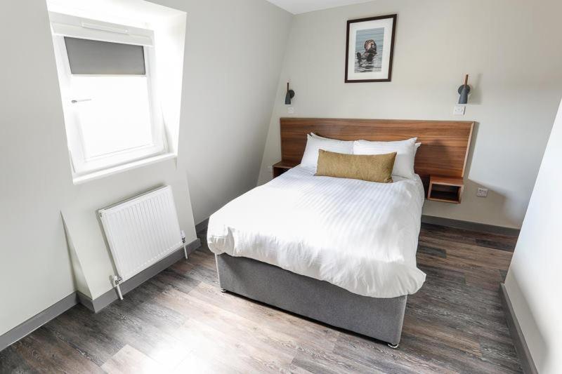 Un dormitorio con una cama grande y una ventana en Broadcroft Hotel en Kirkintilloch