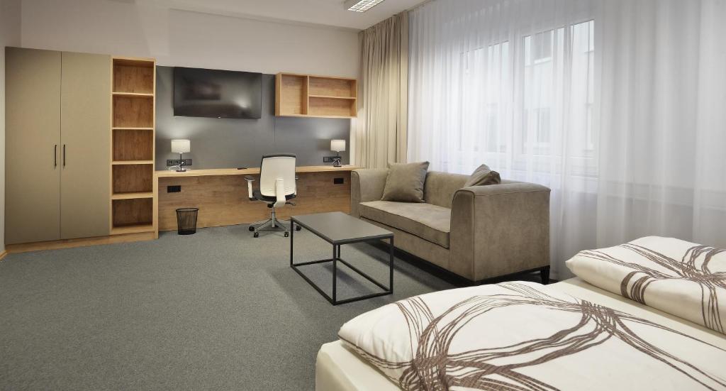 ein Hotelzimmer mit einem Bett, einem Schreibtisch und einem Stuhl in der Unterkunft BELLEVUE-Boardinghouse in Lichtenfels