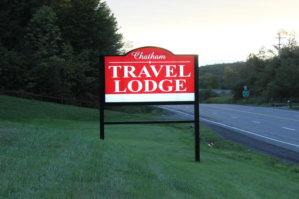 una señal para un lodge de viaje al costado de una carretera en Chatham Travel Lodge, en Old Chatham