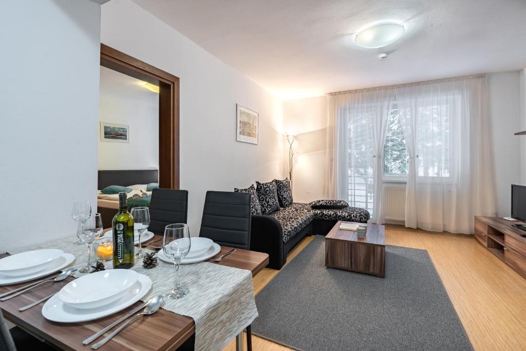 een woonkamer met een eettafel en een bank bij Wili Tatry Apartments in Tatranská Lomnica
