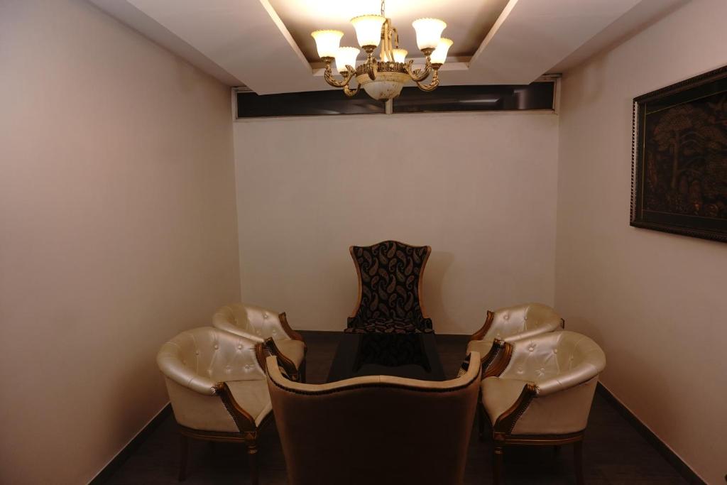 a room with chairs and a table and a chandelier at Ramada Plaza By Wyndham, Chandigarh Zirakpur in Chandīgarh