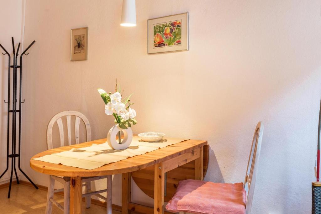 een eettafel met een vaas met bloemen erop bij Ferienwohnung Faden in Konstanz