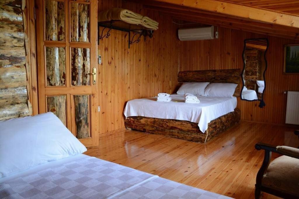 1 dormitorio con 2 camas en una cabaña de madera en Ala Otel Konuk Evi Agva, en Sile