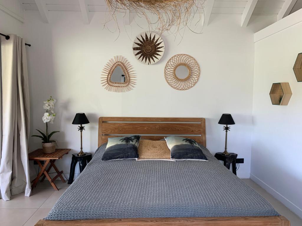 a bedroom with a bed and two mirrors on the wall at CENTRAL PALM in Saint Barthelemy