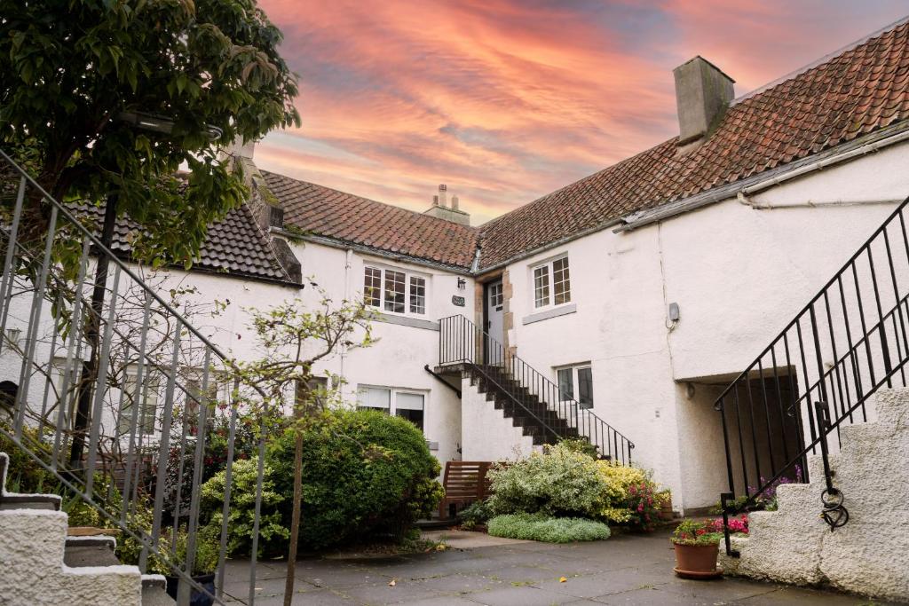 a row of white houses with a sunset in the background at Courtyard at Crail in Crail