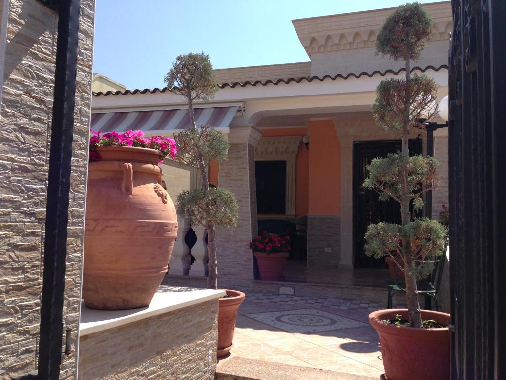 duży wazon z drzewami w nim przed domem w obiekcie Villa Ortensia, villa in Alto Salento w mieście Torre Ovo