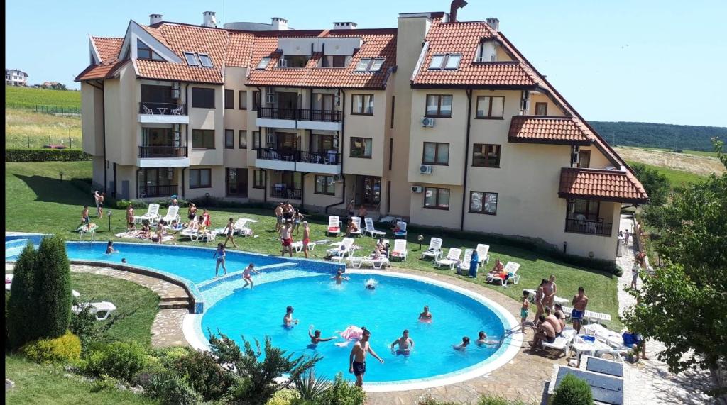 a group of people in a swimming pool in front of a building at CarolMike Oasis Beach Apartment Kamchia Reserve in Kamchia