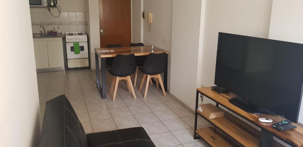 een woonkamer met een tafel met stoelen en een televisie bij Torres del Centro - Av Colón esq Gral paz in Cordoba