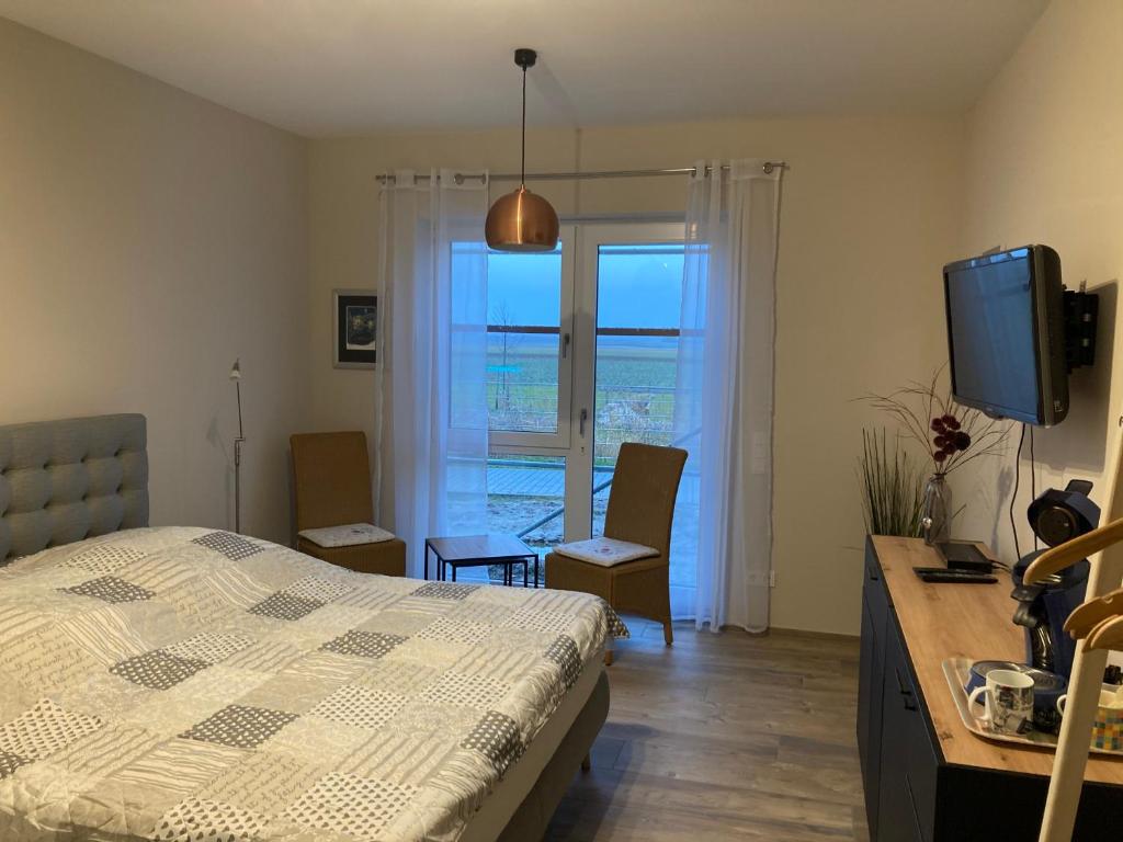 a bedroom with a bed and a desk and a television at Doppelzimmer mit Ausblick in Siefersheim