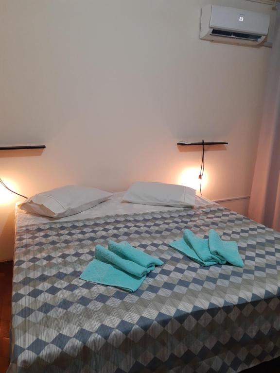 Una cama con dos toallas azules encima. en Casa Livramento Rivera diária, en Santana do Livramento