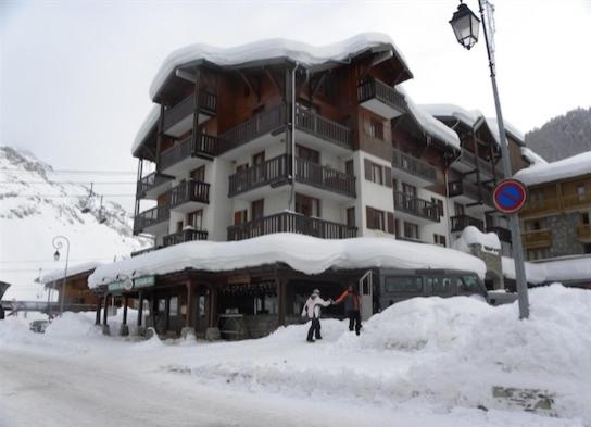 two people standing in the snow in front of a building at Val-d'Isère - 2 pièces + cabine au pied des pistes in Val dʼIsère