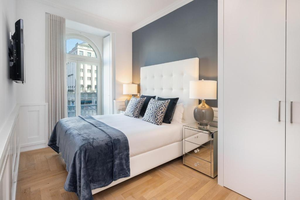 1 dormitorio con cama blanca y ventana en WHome | The Boulevard Prime Location & Timeless Luxury, en Lisboa