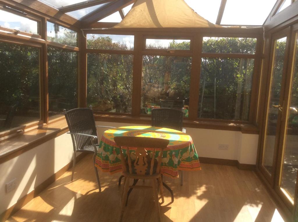 a screened in porch with a table and chairs at Lower Thura House in Wick