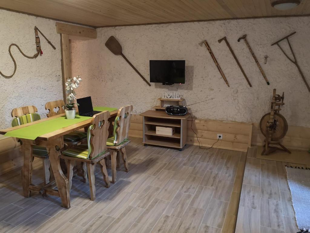 een eetkamer met een tafel met stoelen en een tv bij chalupa samo in Lúčky