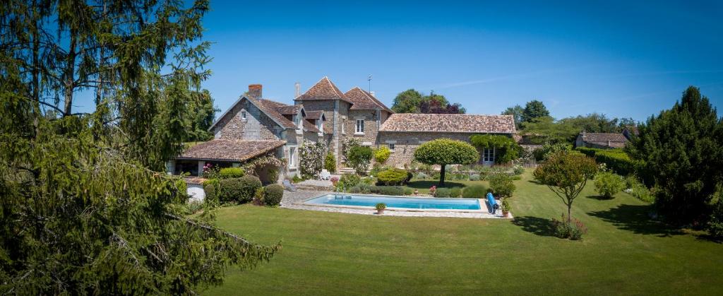 Vouneuil-sur-VienneにあるChambres d'Hôtes La Pocterieの庭にスイミングプールがある大きな家