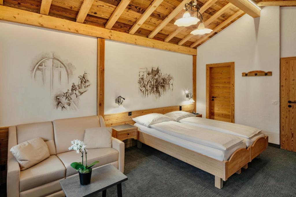 1 dormitorio con 1 cama y 1 sofá en Hotel Antika, en Zermatt