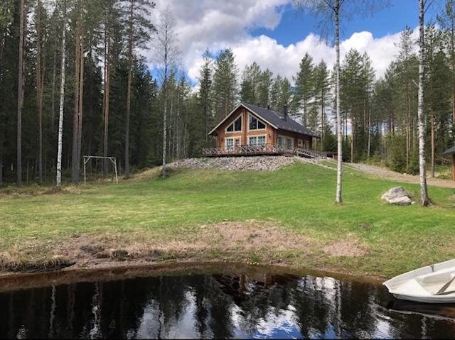 uma casa no topo de uma colina ao lado de um lago em Jämsän Lomamökit em Jämsä
