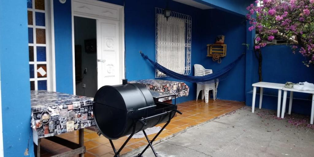 uma televisão num quarto com uma parede azul em Casa Praia dos Anjos - 50m da praia em Arraial do Cabo